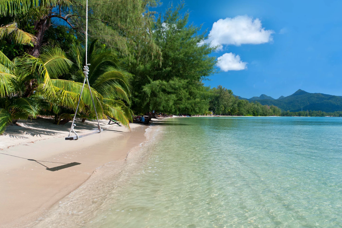 Secluded tropical beach in Thailand with turquoise water and cloudy sky in May