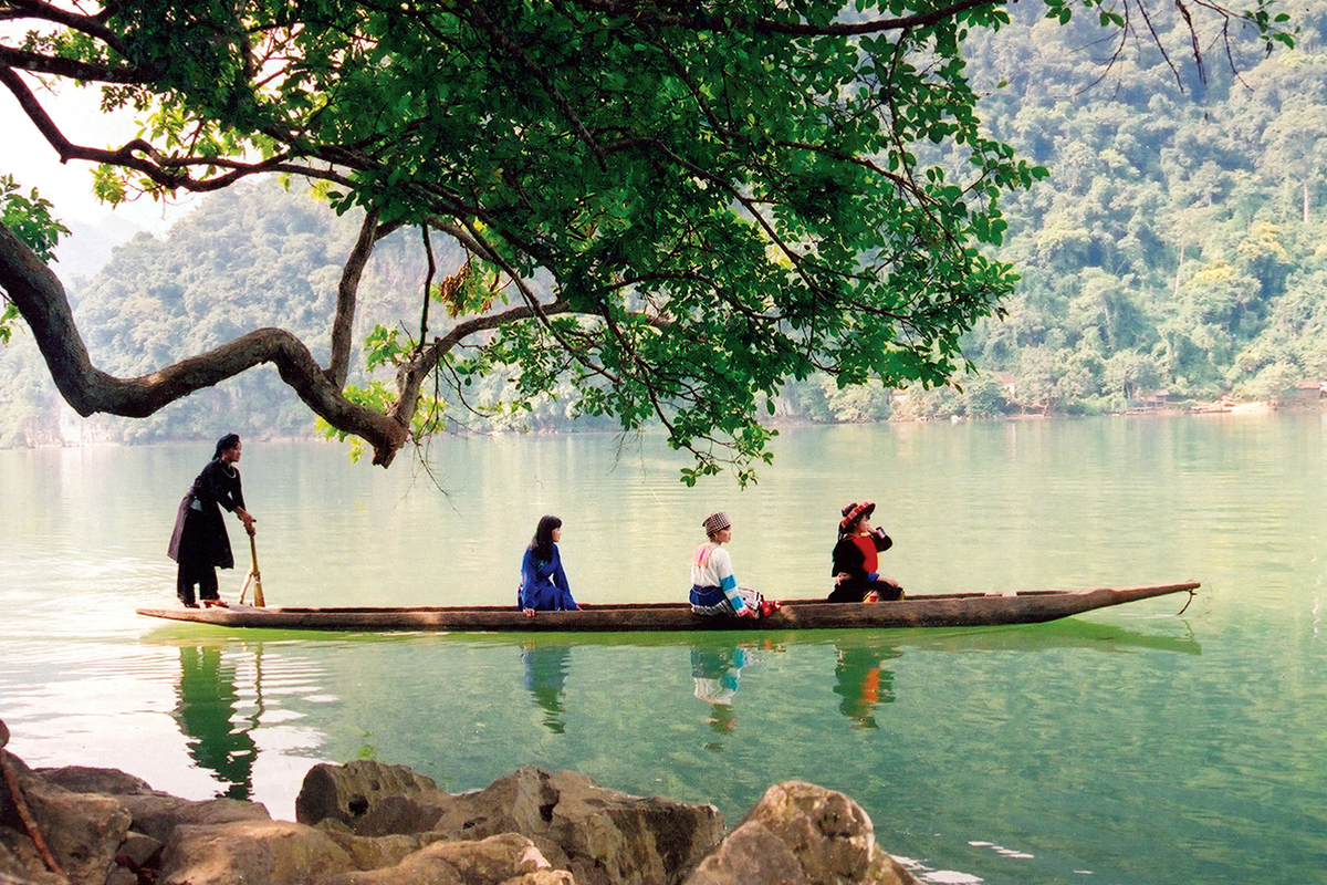 Panoramic view of Ba Be Lake surrounded by lush forested mountains in Northern Vietnam