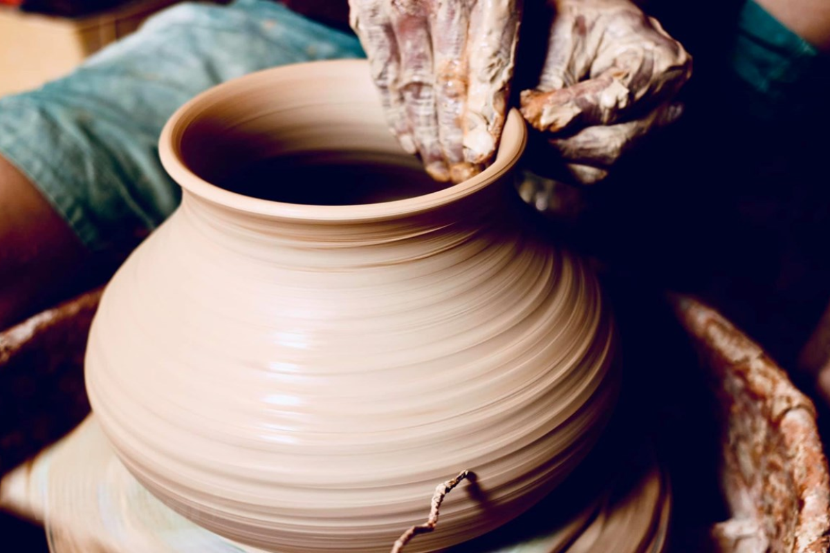 Artisan shaping clay at Bat Trang Pottery Village
