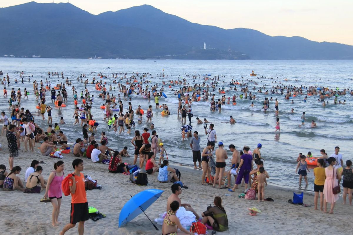 Sunny beach in Da Nang crowded with summer visitors