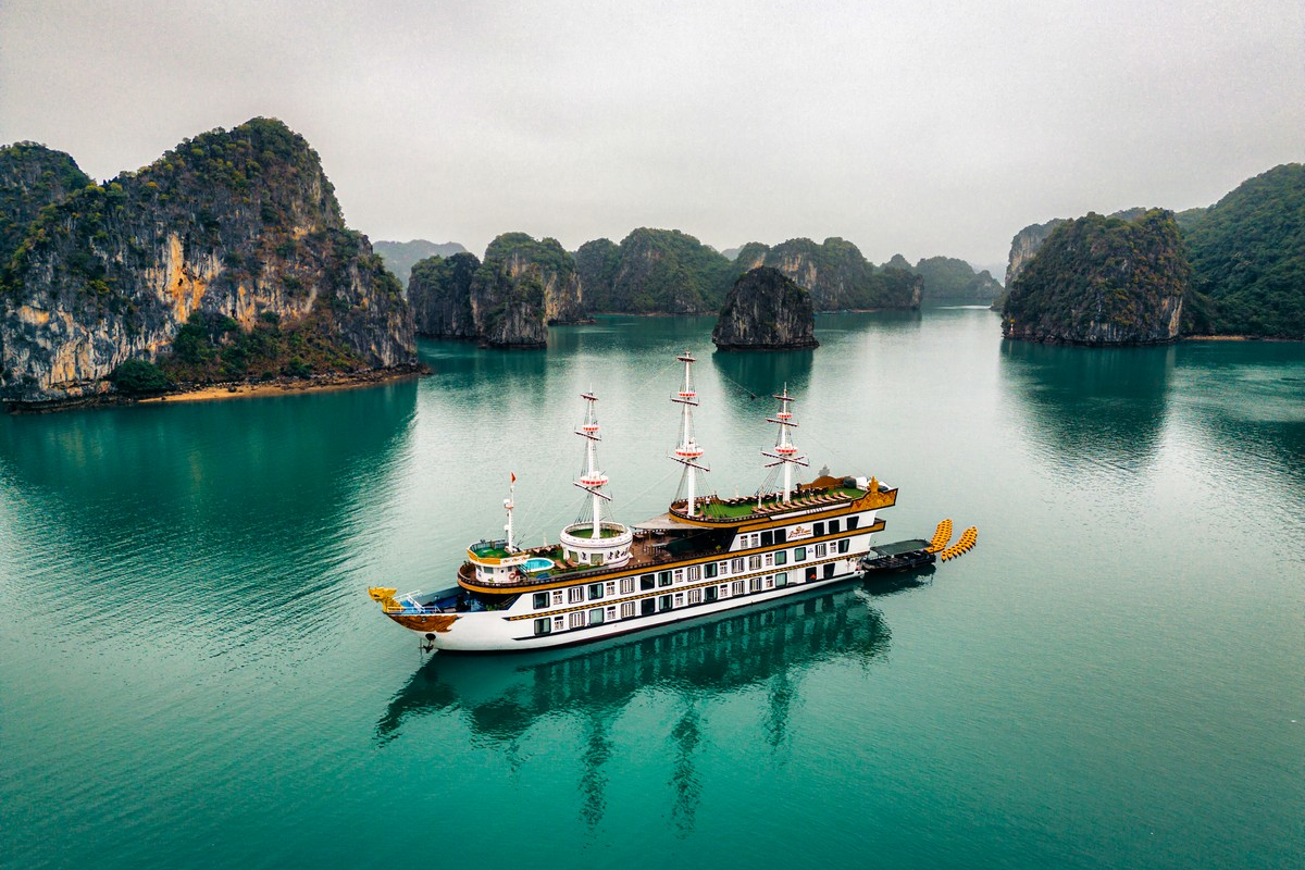 A cruise ship sailing among limestone islets in Halong Bay