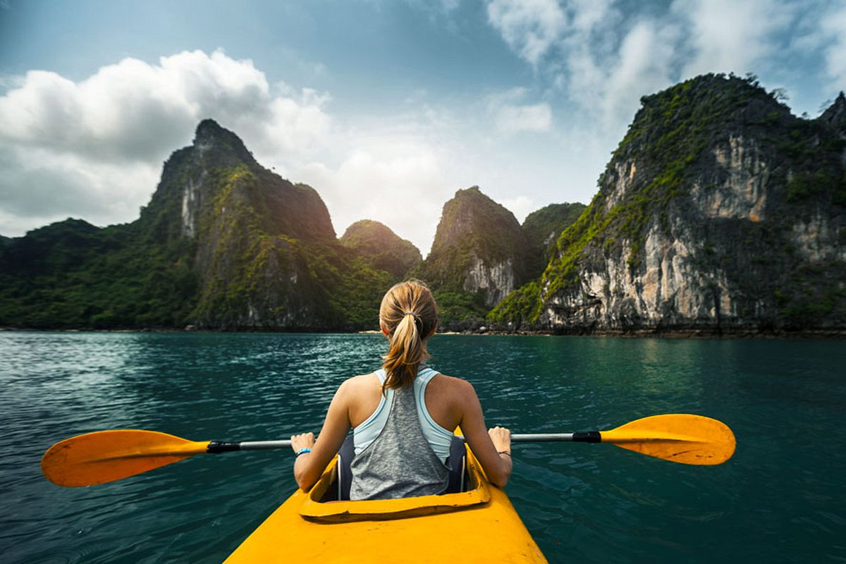 Tourists kayaking in Halong Bay under sunny skies