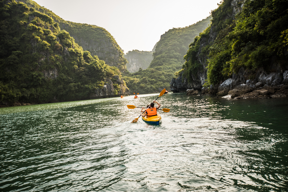 Tourist kayaking between limestone karsts in Ha Long Bay