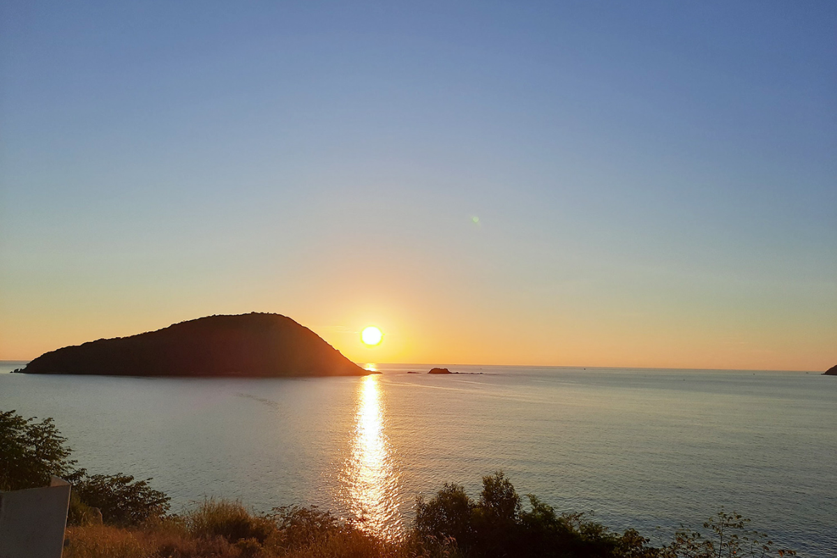 Sunset casting golden hues over the calm waters of Lo Voi Beach