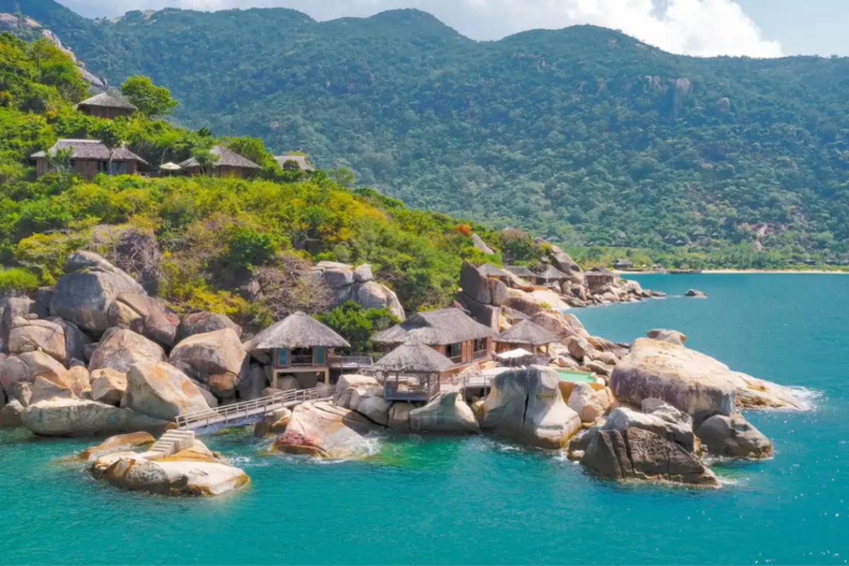 Peaceful beach surrounded by green hills and clear water at Ninh Van Bay