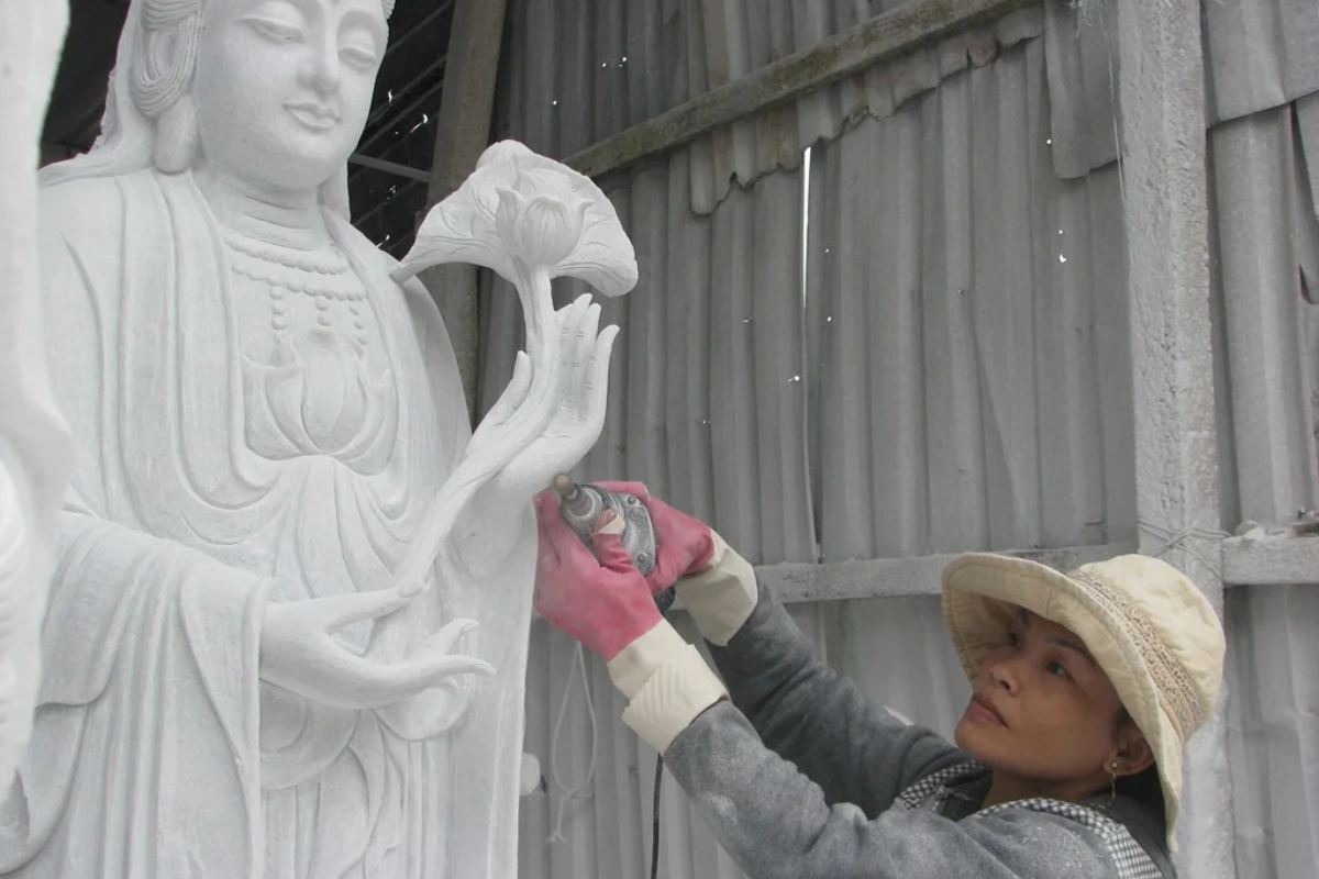 Skilled artisans carving marble statues at Non Nuoc Stone Carving Village