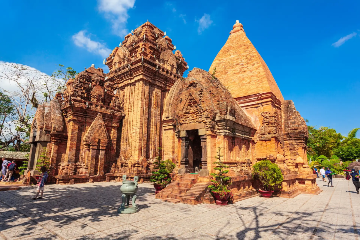 Ancient Ponagar Cham Towers surrounded by lush greenery and blue sky