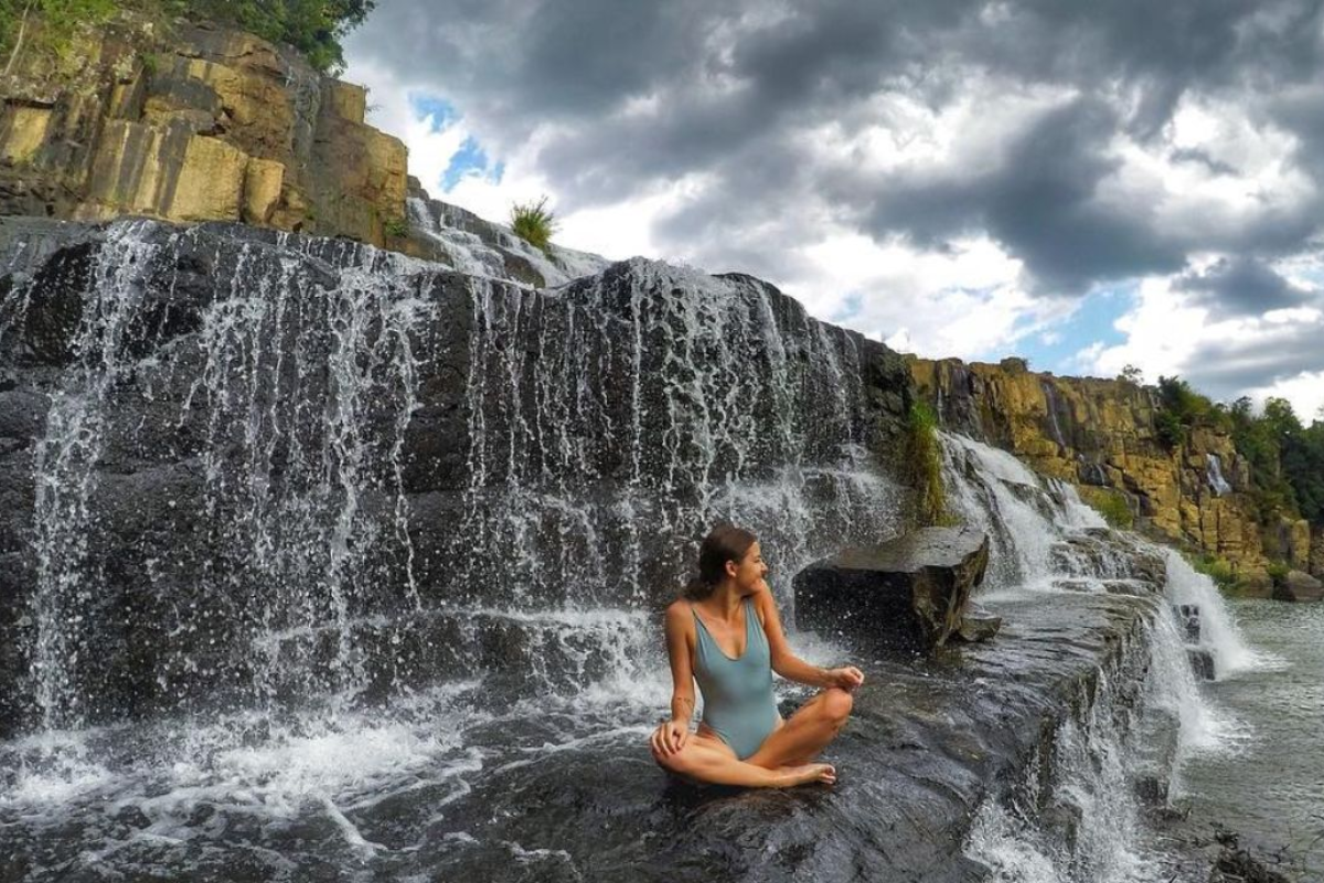 Pongour Waterfall flowing over rocky tiers into the lush forest in Da Lat during the rainy season