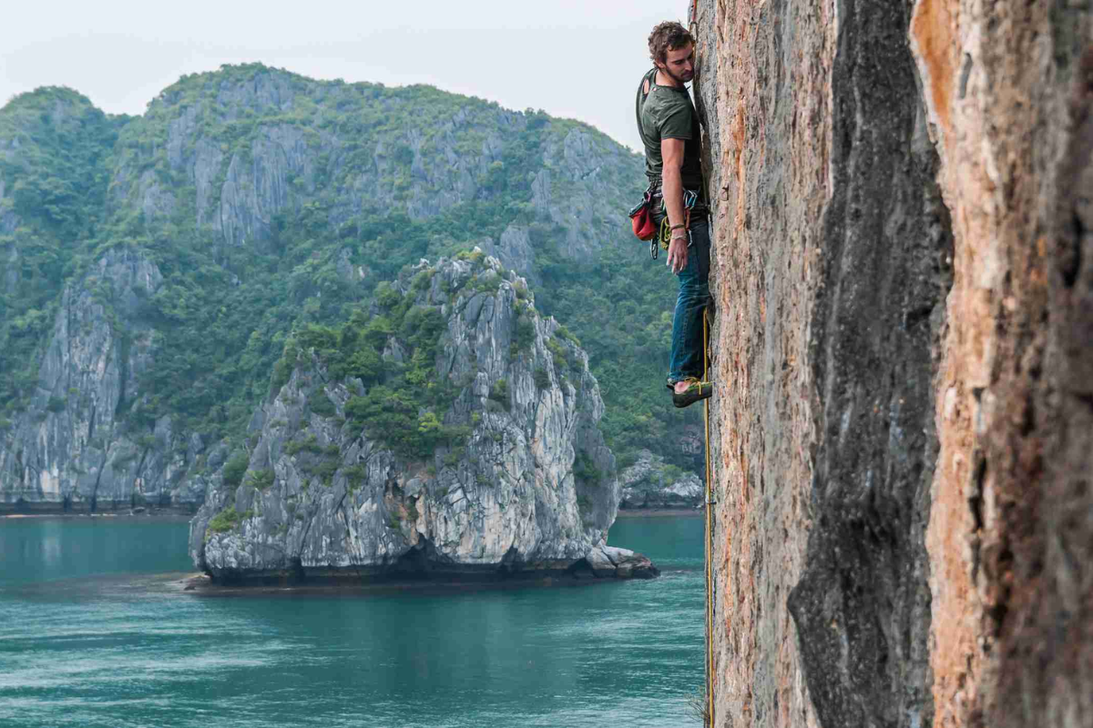 Climber scaling a limestone cliff in Ha Long Bay 