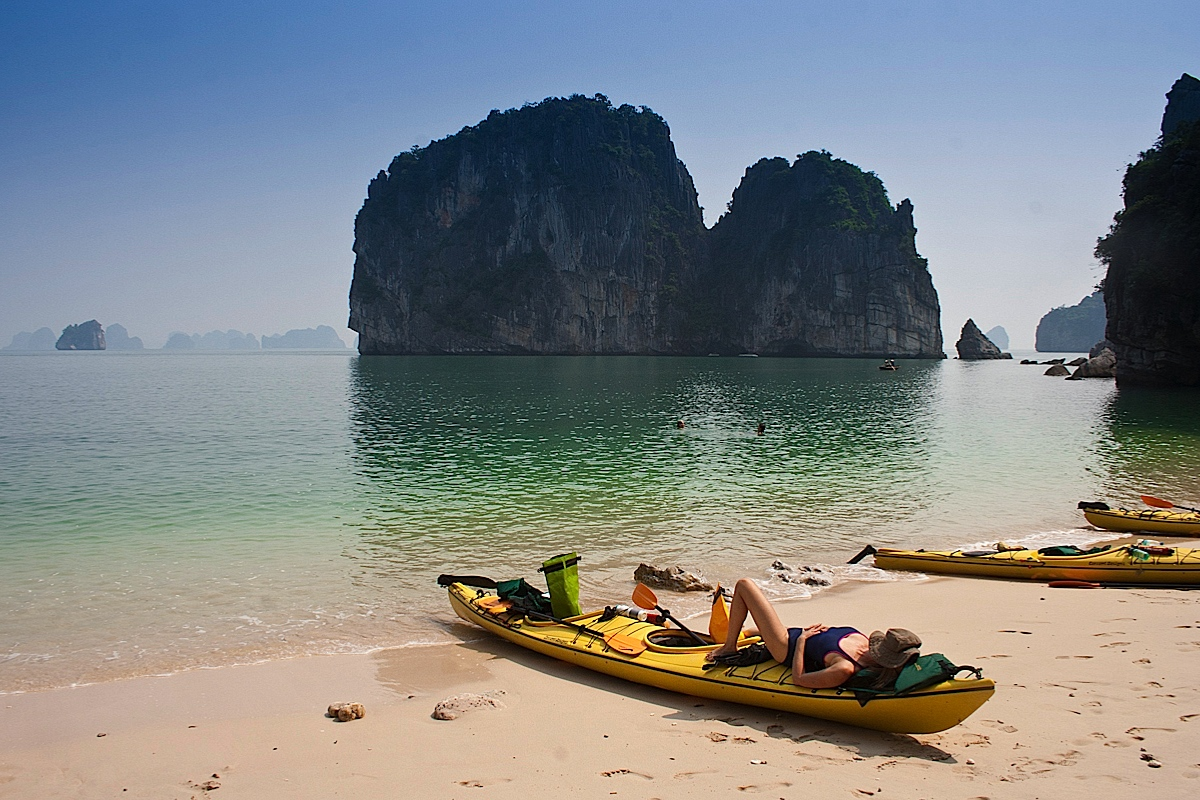 Visitors sunbathing and relaxing on a quiet beach in Ha Long Bay