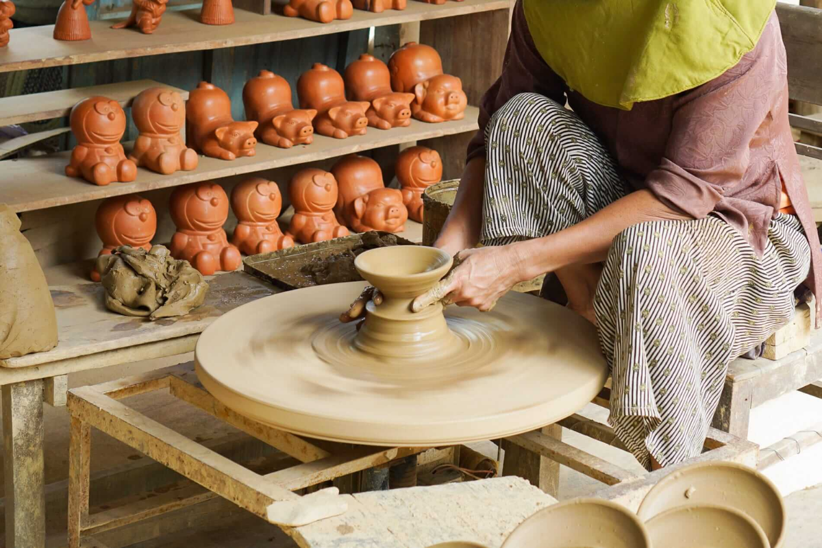 Local artisan shaping pottery by hand at Thanh Ha Village