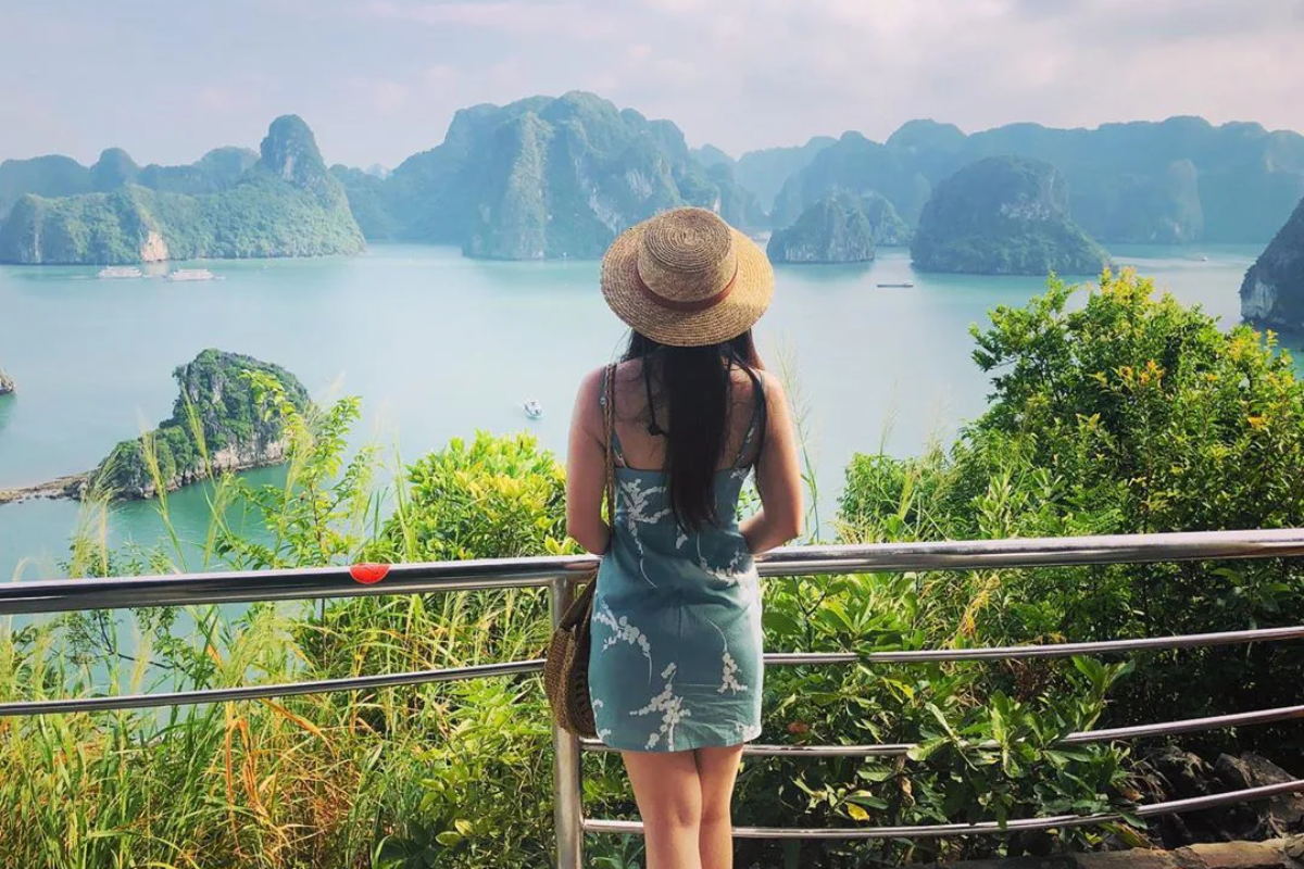 Tourists hiking Ti Top Island with Ha Long Bay in the background