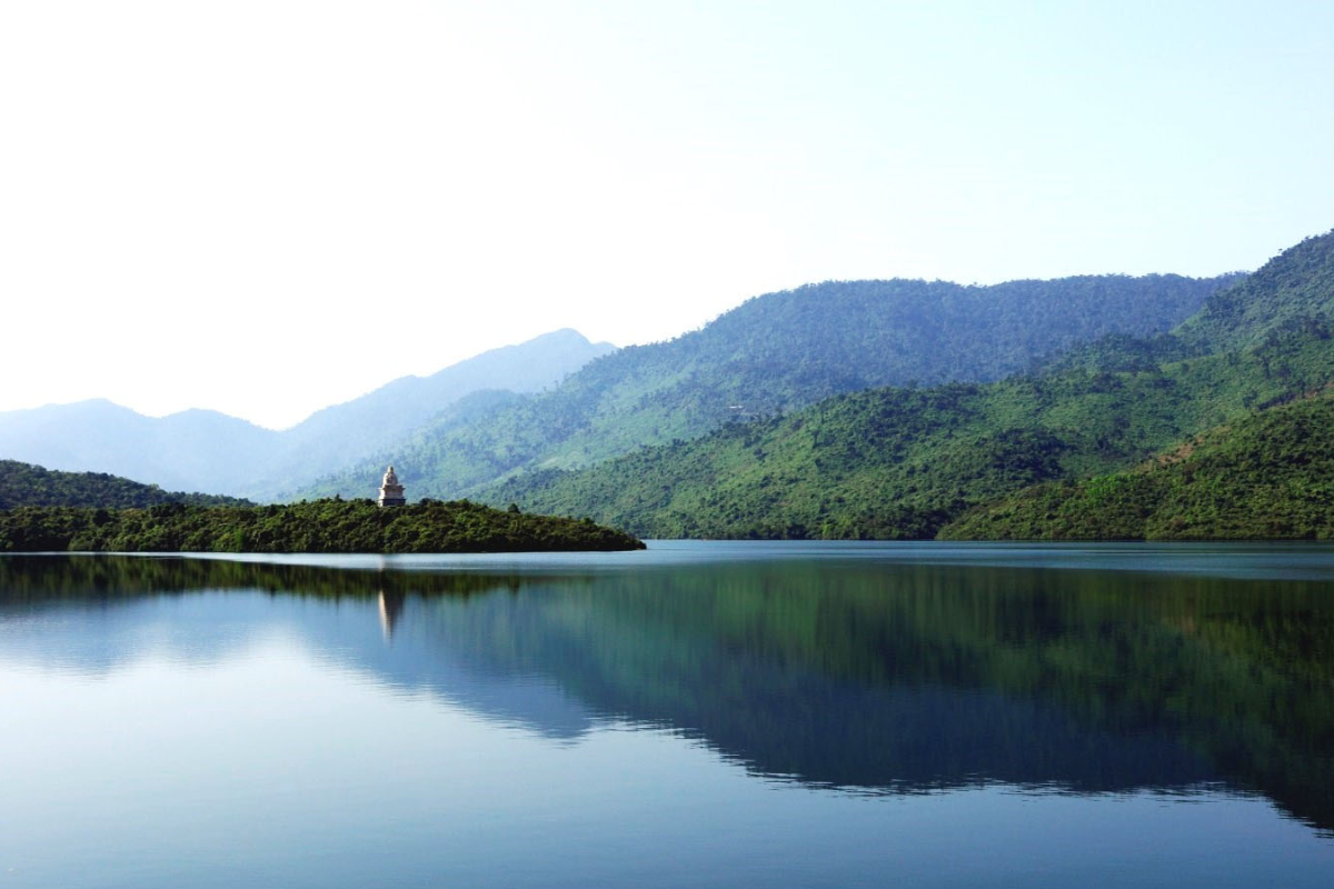 Tranquil view of Truoi Lagoon with green mountains in the background