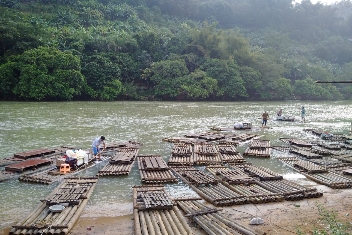 Tourists taking a bamboo raft ride near Ban Gioc Waterfall in the rainy season