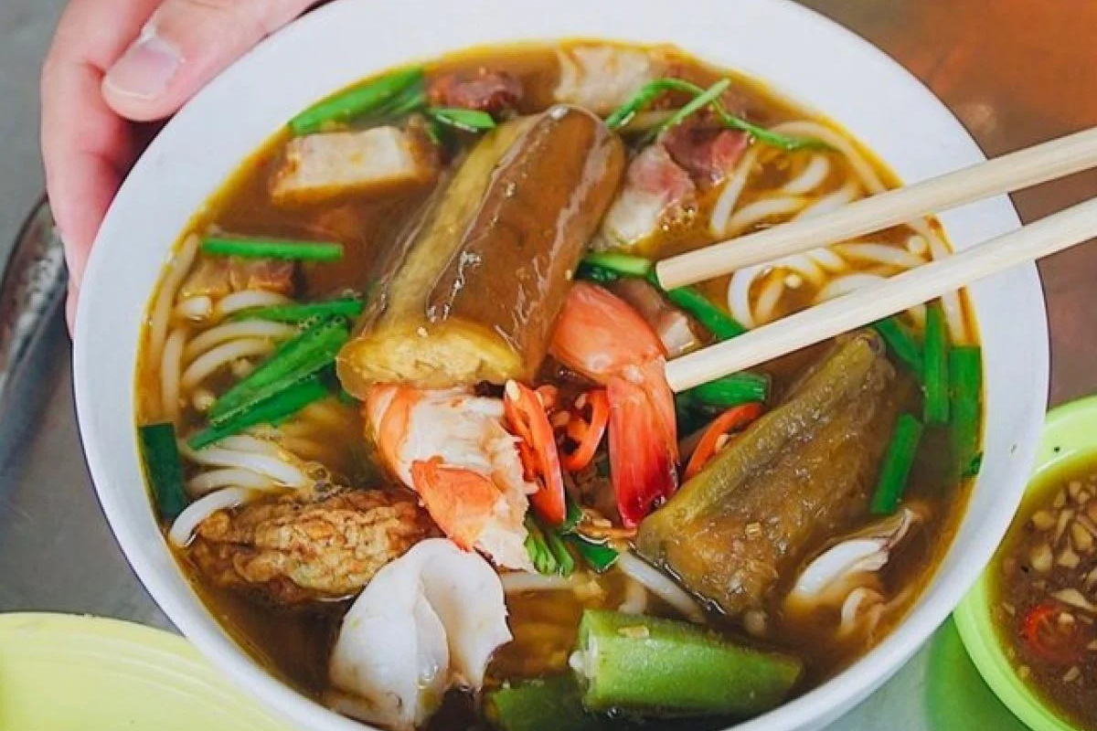 Bowl of Bún Mắm with noodles, seafood, herbs, and fermented fish broth