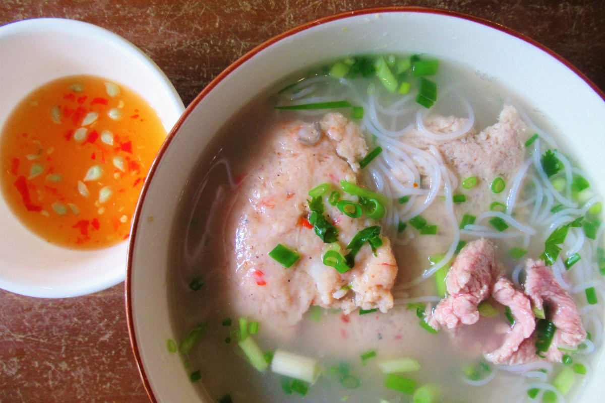 A bowl of Bun Quay, a famous noodle dish in Phu Quoc, with fresh herbs and seafood