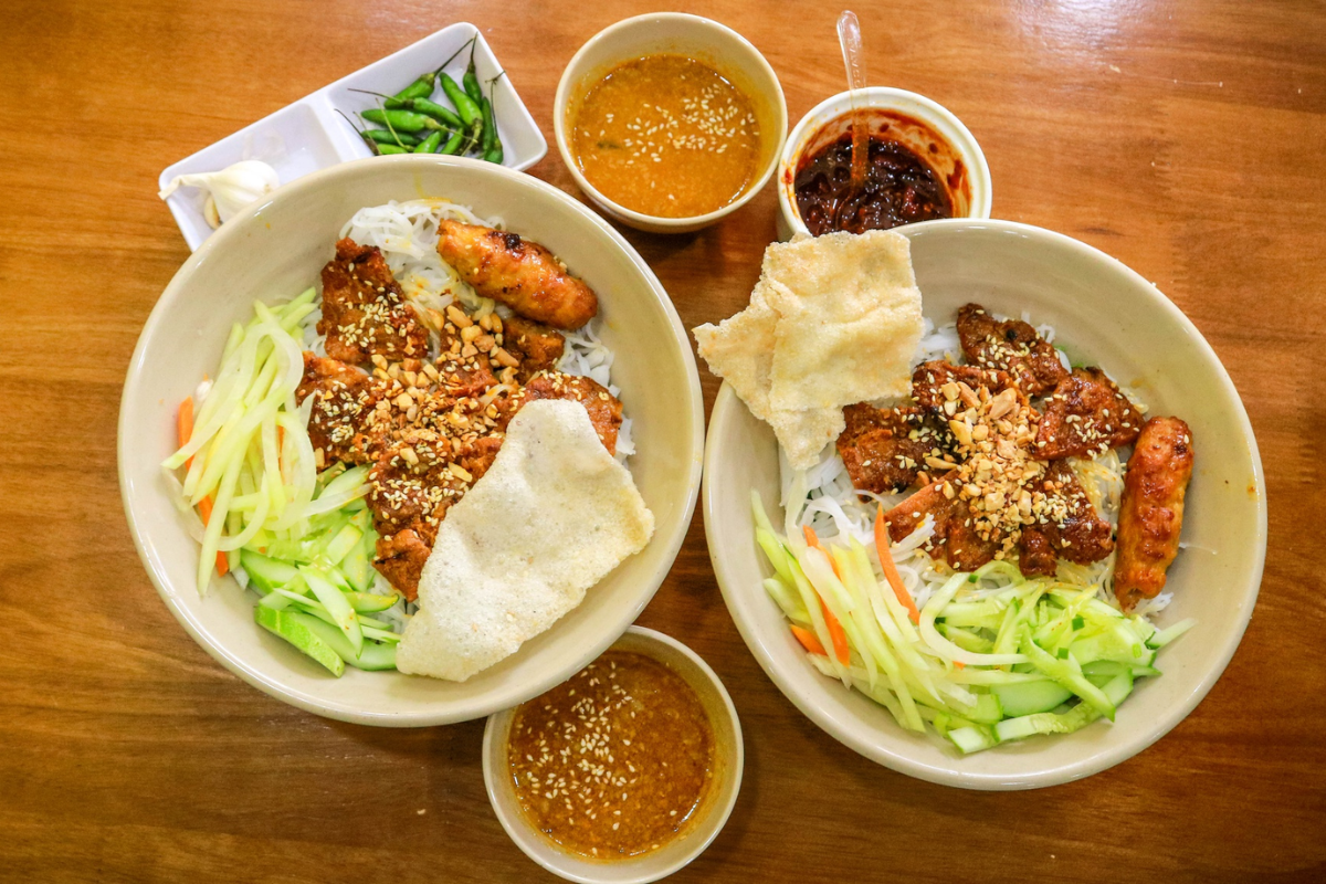 A plate of Bun Thit Nuong with fresh vegetables and peanut sauce