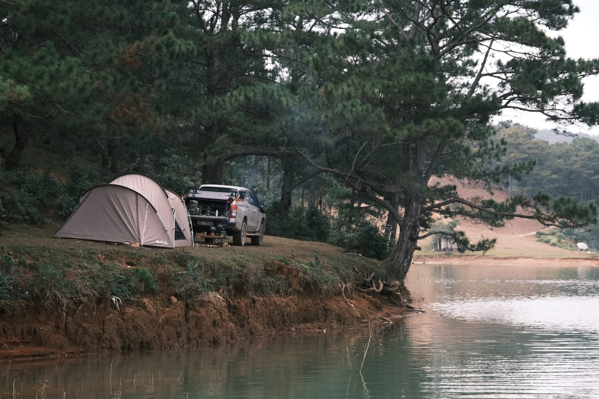 Tent near Tuyen Lam Lake at sunrise with mountain mist