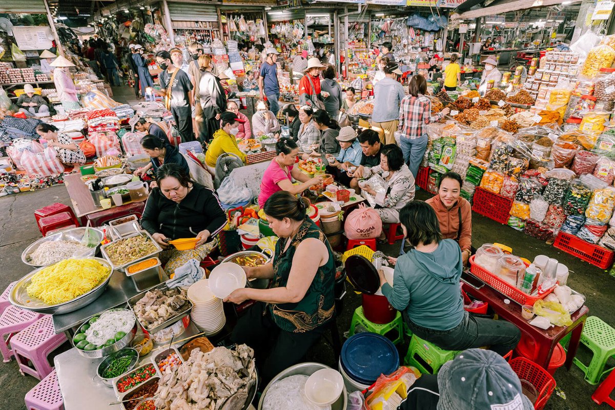 A busy scene at Con Market, Da Nang, with colorful stalls selling local goods