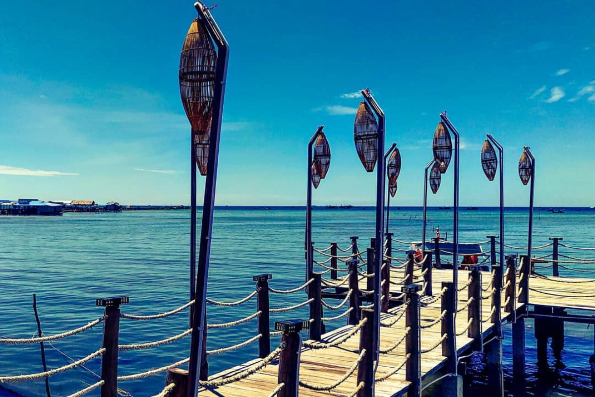 A rustic wooden bridge at Ham Ninh fishing village with a stunning sea view