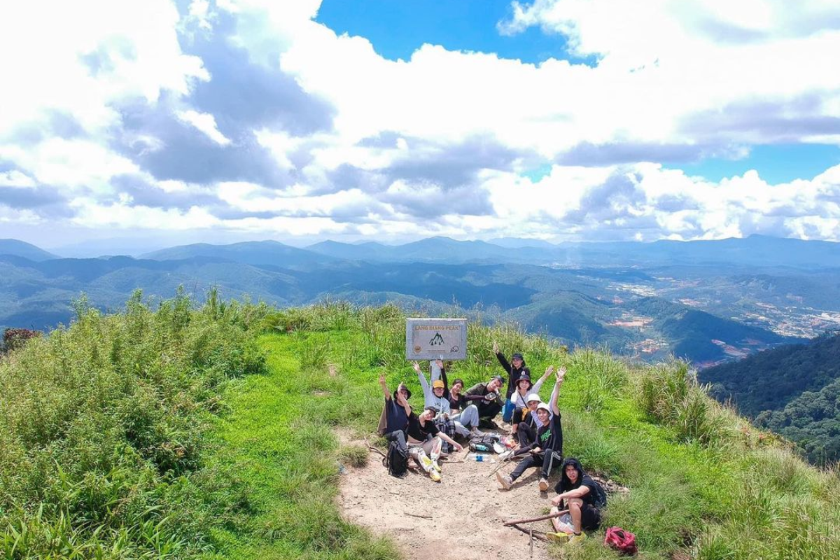 Hiker overlooking green hills under a clear September sky in Da Lat