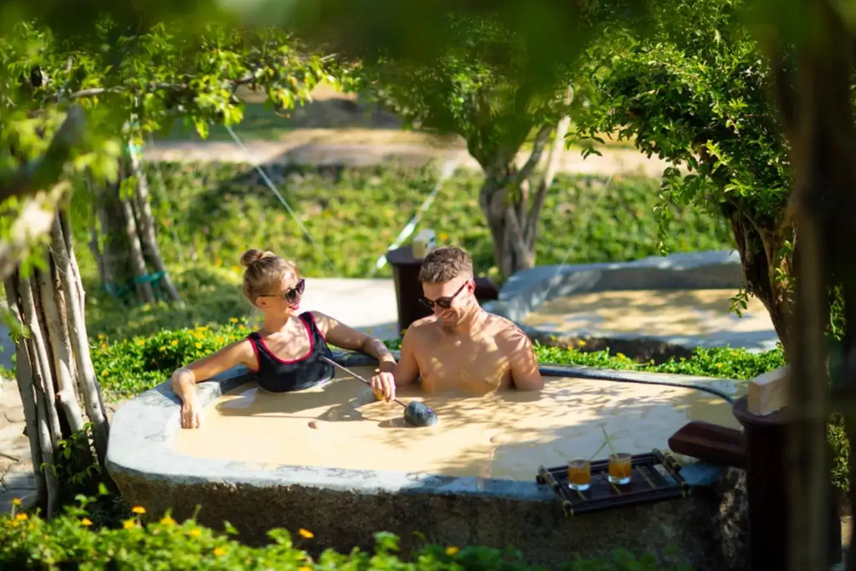 Tourists enjoying a mud bath on Hon Tam Island