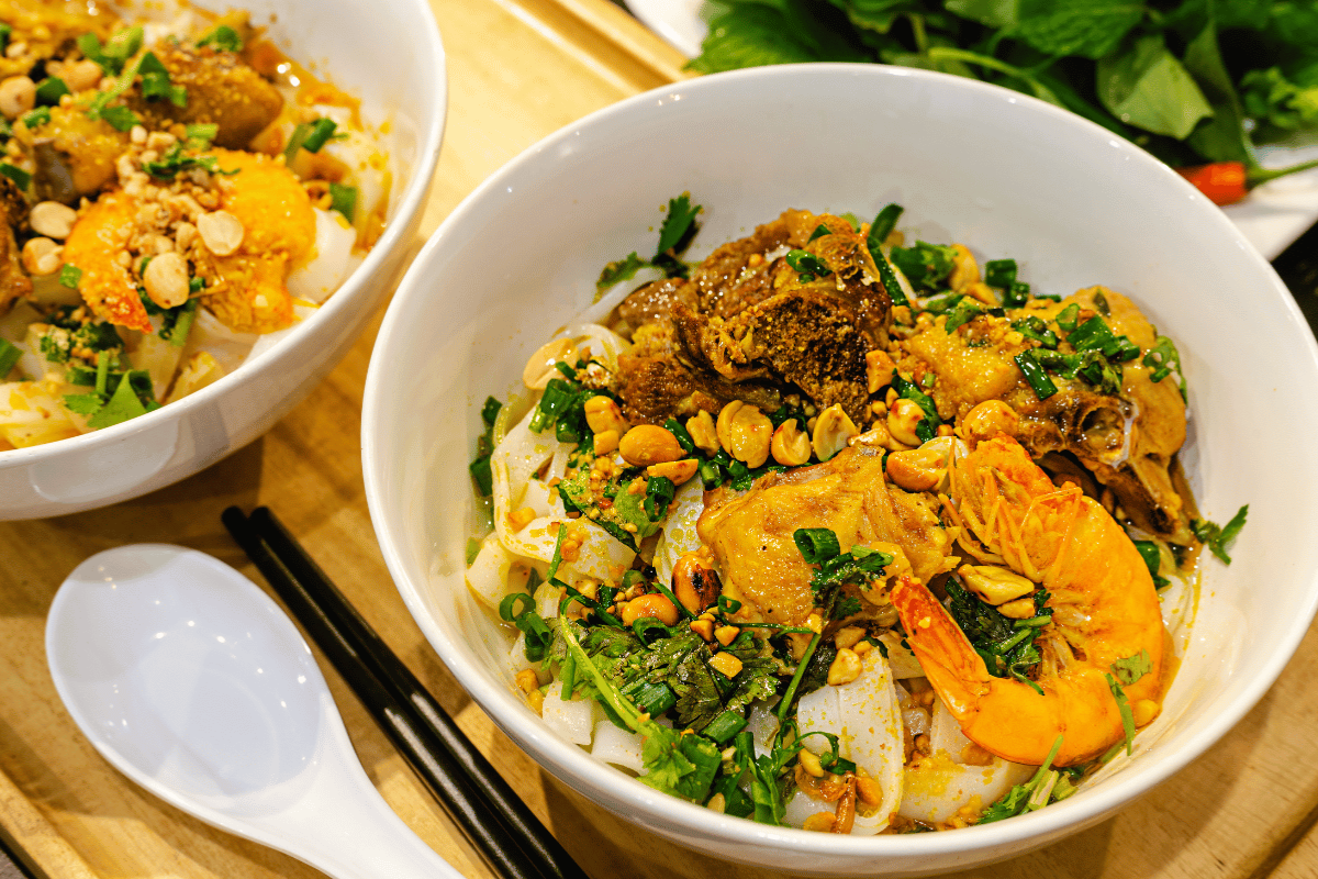 A plate of delicious Vietnamese food, including Mi Quang and Banh Xeo