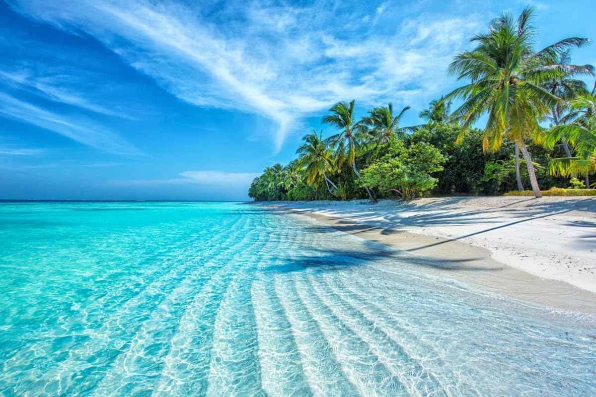 Soft sandy beach and calm turquoise sea in Nha Trang under sunny skies