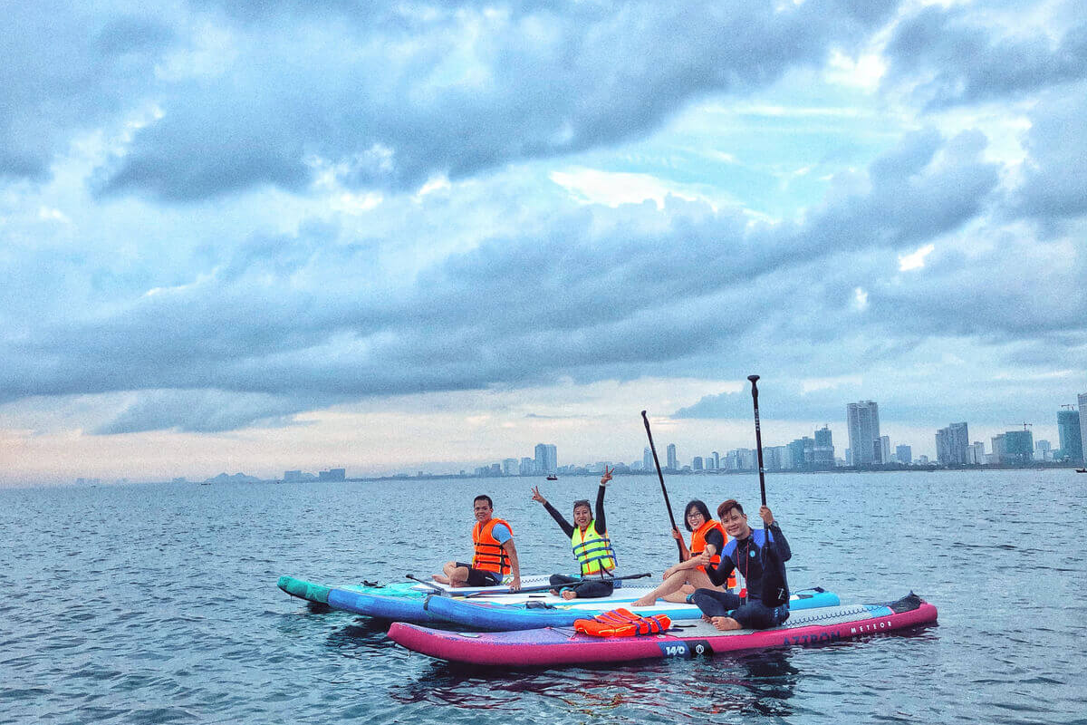 Tourists engaging in water sports such as surfing and jet skiing at Non Nuoc Beach
